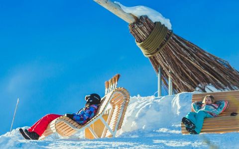 Zwei Kinder sitzen vor dem grossen Hexenbesen, welcher sich auf der Belalp befindet.